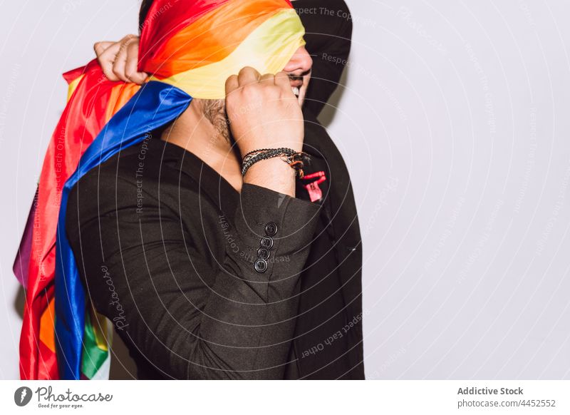 Schwuler Mann bedeckt Gesicht mit LGBT-Flagge schwul Regenbogen Fahne umhüllen Stolz Symbol Gemeinschaft Respekt Homosexualität männlich Solidarität mehrfarbig
