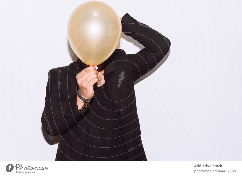 Mann bedeckt Gesicht mit Luftballon auf Party Veranstaltung Tierhaut Feiertag feiern Anlass Überraschung Deckblatt männlich Studioaufnahme gratulieren inkognito
