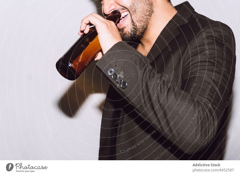 Fröhlicher bärtiger Mann trinkt Bier im Gesicht aus einer Flasche feiern Party Schnaps genießen Feiertag Spaß Anlass männlich Glas Alkohol heiter trinken