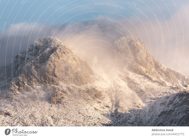 Verschneiter Berghang unter Wolken an einem Wintertag Schnee Berge u. Gebirge steil kalt Natur Landschaft Ambitus Hochland Frost Felsen wild Cloud Formation