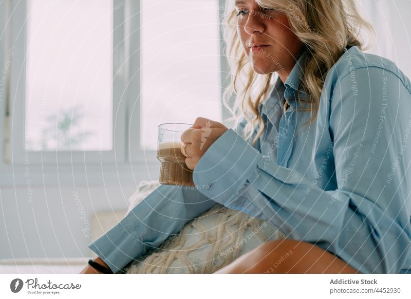 Crop-Frau mit Latte ruht im Haus Zimmer Kaffee reflektierend wehmütig besinnlich Heißgetränk Getränk einsam heimwärts Hemd Kissen dekorativ natürlich Aroma