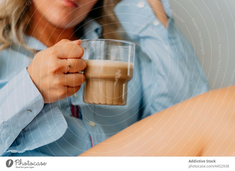 Verträumte Frau genießt köstlichen Milchkaffee zu Hause trinken Latte Kaffee Heißgetränk Getränk natürlich Aroma heimwärts schäumen aromatisch Tasse Wittern