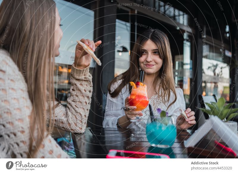 Crop lächelnde Jugendliche mit Cocktails im Gespräch in städtischen Café bester Freund Snack reden sich[Akk] sammeln trinken Getränk Inhalt Straße Freundin Glas