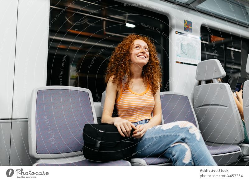 Fröhlicher Fahrgast mit gekreuzten Beinen im Zug Passagier reisen heiter Arbeitsweg Beine gekreuzt offen freundlich Sitz Frau charmant charismatisch zerrissen