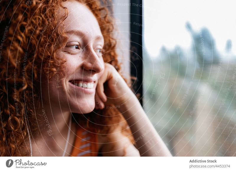 Lächelnder Fahrgast, der im Zug aus dem Fenster schaut Passagier herausschauen zuhören Musik Kopfhörer Frau benutzend Apparatur Gerät Gesang Melodie Audio Klang