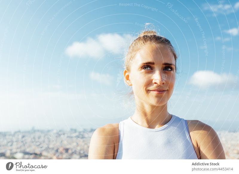 Sportlerin betrachtet die Stadt im Sonnenschein selbstbewusst verträumt sportlich Gesunder Lebensstil Wellness Vitalität Blauer Himmel Porträt Frau herzlich