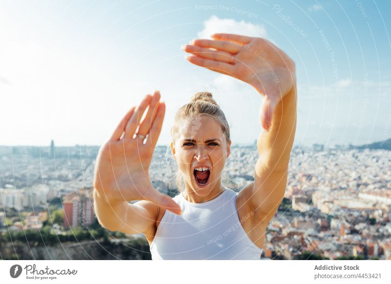 Sportlerin schreit beim Training in der Stadt und zeigt Rahmengesten Schrei wütend angriffslustig Wut Foto Porträt Frau Schreien Sie Mund geöffnet schreien laut