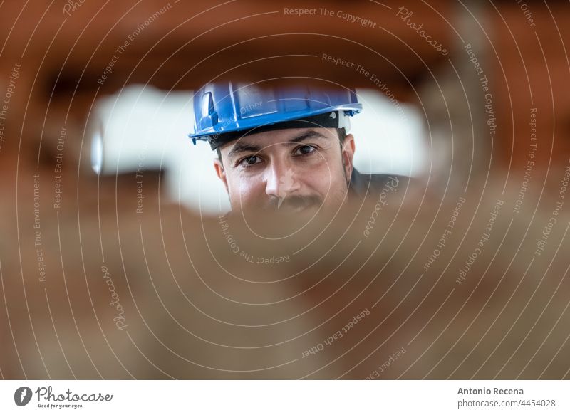 Arbeiter bei Renovierungsarbeiten schaut durch ein Loch, durch das die Lichtschalter kommen werden picola Profil Mann Maurer Job Konstruktion arabisch 40s