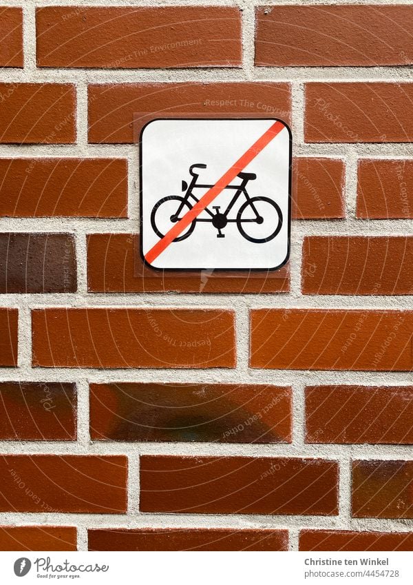 Hier keine Fahrräder abstellen... Piktogramm an einer roten Klinkerfassade Fahrrad durchgestrichen Backsteinmauer Wand parken Hinweis Verbotsschild