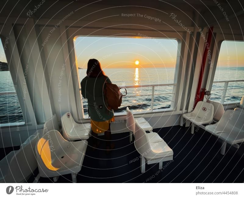 Eine Frau steht an der Reling einer Fähre und blickt übers Meer auf den Sonnenaufgang Reise Fernweh Ferien & Urlaub & Reisen Wasserfahrzeug Passagierschiff