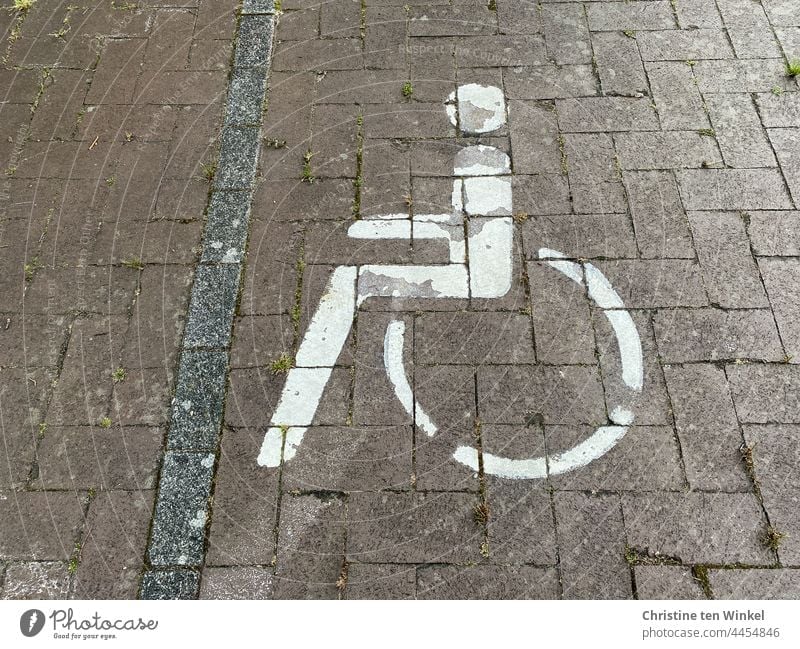 Rollstuhlfahrer Piktogramm auf einem gepflasterten Parkplatz Behindertenparkplatz Behindertengerecht Rollstuhlfahrer-Symbol Gehbehindert Gehbehinderung Zeichen