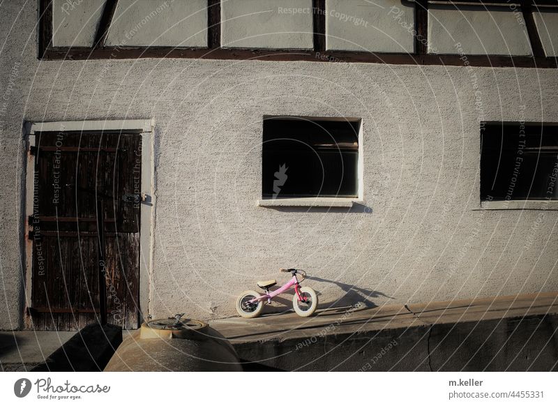 ein Kinderfahrrad lehnt an einer Scheune Landleben Schatten Fahrrad Kindheit Abend