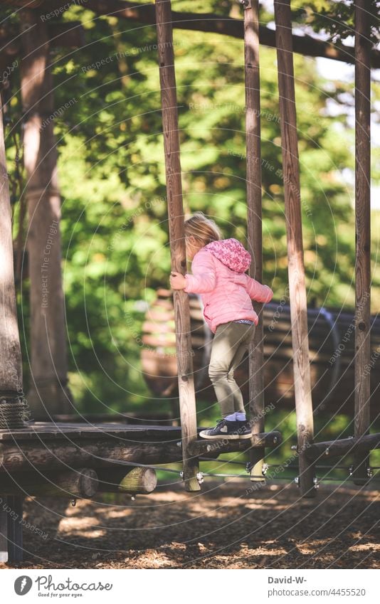 Mädchen klettert auf einem Spielplatz klettern balancieren Gleichgewicht Konzentration Mut Kind Bewegung spielen Kindheit Freude