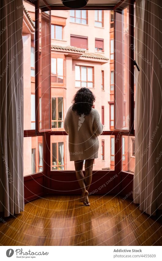 Frau in der Nähe eines geöffneten Fensters am Morgen stehend offen Appartement Harmonie sanft friedlich Unterkunft flach heimisch Gardine heimwärts Barfuß