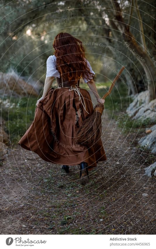 Hexe mit Besen läuft im Wald Besenstiel laufen Frau Zauberin Wälder dunkel Herbst Hexerei Zauberei u. Magie mystisch Zauberer dumpf trist Weg Halloween Kleid