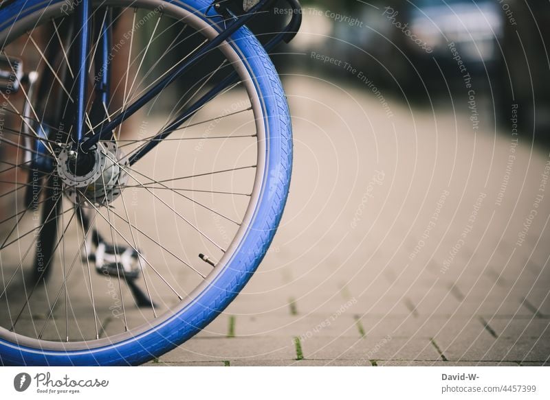 Fahrrad in einer Stadt - blauer Fahrradreifen Rad Fahrradfahren Speichen nachhaltig Verkehrsmittel