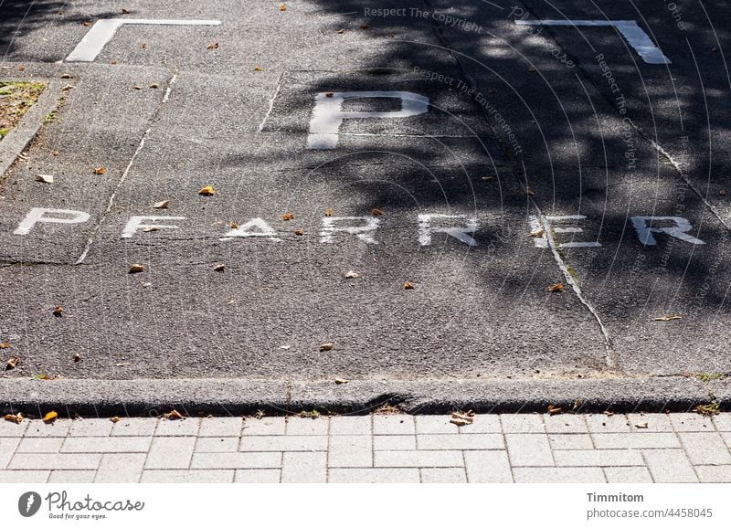 Pfarrer - reservierter Parkplatz Schilder & Markierungen Schriftzeichen Menschenleer asphaltiert Straße Pflastersteine Schatten parken Asphalt grau