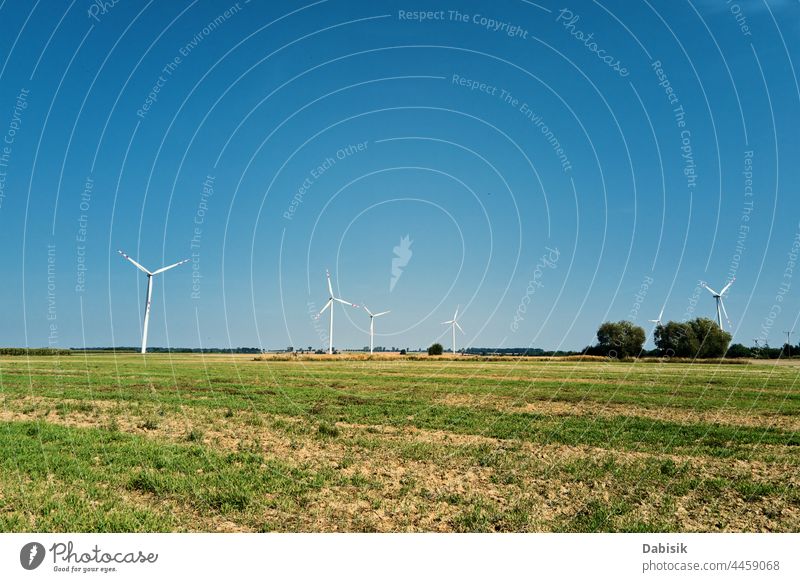 Windrad inmitten landwirtschaftlicher Felder. Windturbinengenerator an einem Sommertag. Windenergie-Konzept. Nachhaltige und erneuerbare Energie für den Klimaschutz. Grüne Energie