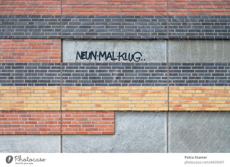 Neun mal klug Neun mal Klug Text Schrift Zeichen Schriftzeichen Buchstaben Wort Graffiti Wand Fassade Mauer Außenaufnahme Farbfoto Menschenleer keine Person