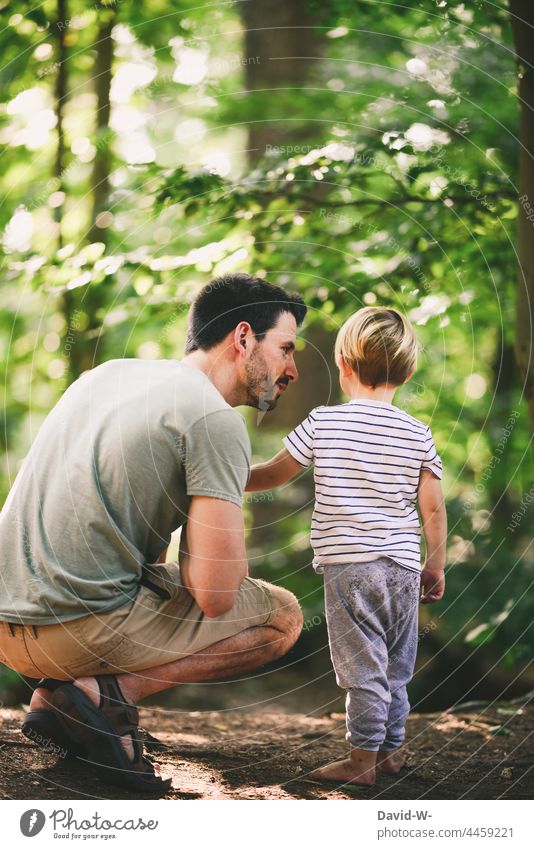 Vater und Sohn gemeinsam im Wald erklären zusammen spielen Papa Kind Fürsorge zeigen Eltern Natur drausen