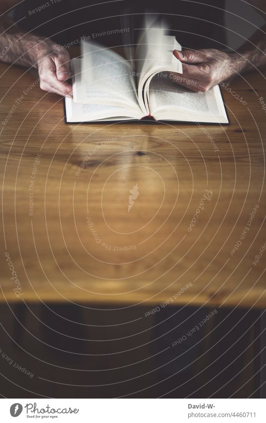 Mann blättert in einem Buch lesen blättern Nachschlagen Tisch lernen Hände Bildung suchen Seiten