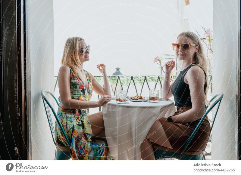 Fröhliche Frauen trinken Cocktails auf dem Balkon Freund Zuprosten genießen Klirren jubelt Mittagessen feiern Zusammensein heiter Tisch bester Freund Glas