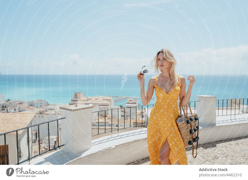 Frau im Kleid steht auf Balkon und genießt die Meereslandschaft Reisender MEER bewundern Großstadt Ausflug beobachten Küste Urlaub alt reisen Tourismus Tourist