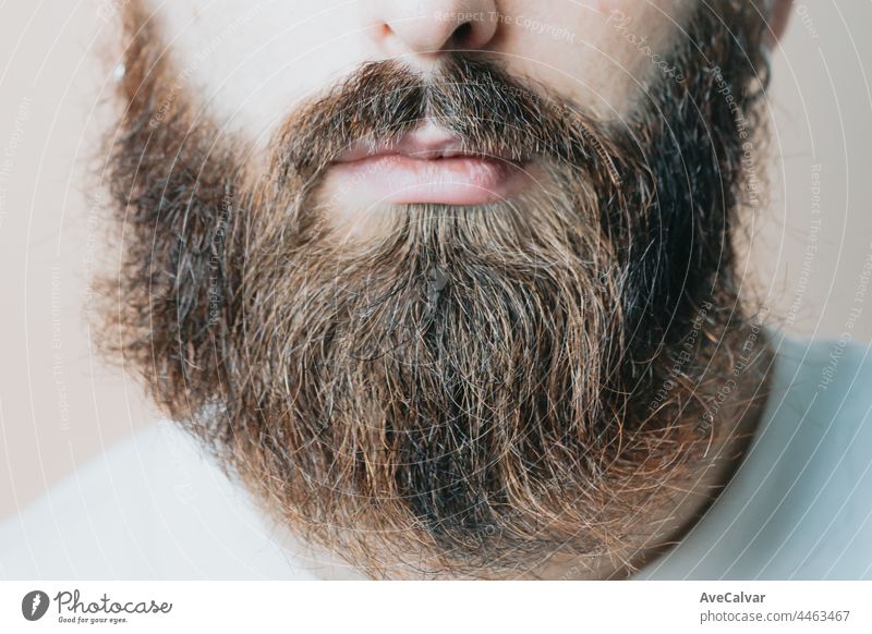 Hübscher bärtiger Mann rasiert seinen Bart, Junger kaukasischer bärtiger Mann trimmt seinen Bart zu Hause während der Quarantäne. Lifestyle-Konzept. männlich