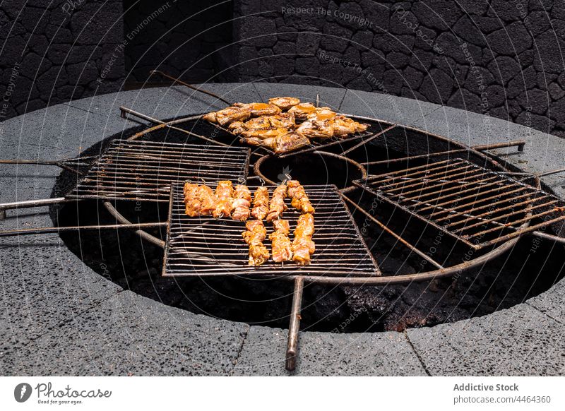Grillhähnchen auf Gestell Hähnchen Barbecue vorbereiten Grillrost Vulkan erwärmen lecker Ablage Aroma Federvieh Protein Spielfigur Koch Insel Prozess Stein