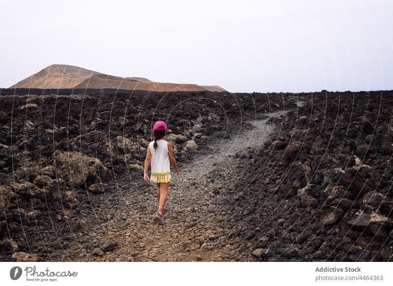 Kleines Mädchen geht auf einem Pfad zwischen Lava Spaziergang Weg Kind Vulkan Natur erkunden Himmel Hochland caldereta Landschaft Geologie unfruchtbar Insel