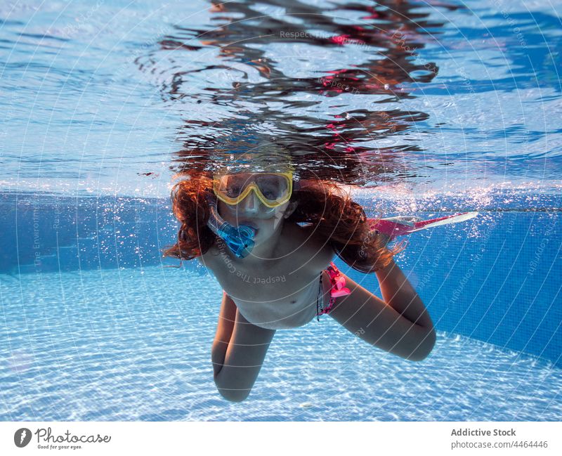 Mädchen mit Schnorchelmaske schwimmt im Pool schwimmen Mundschutz unter Wasser entspannend Aktivität Kindheit Porträt Badeanzug Tauchen Schnorcheln ohne Hemd