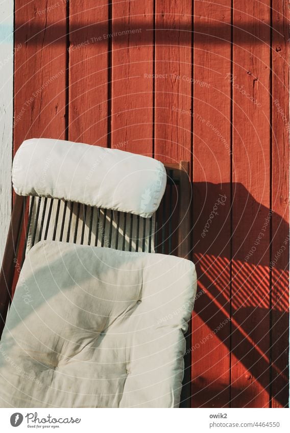 Sitzecke Gartenlaube Wand Holz Bretterwand röt tiefrot Liegestuhl Kissen einfach weich gemütlich Linien