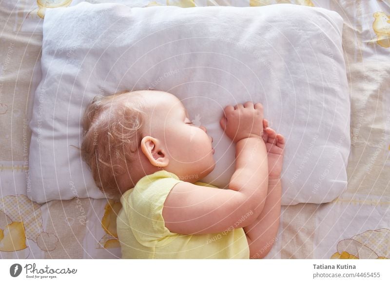 Das Baby schläft auf der Seite auf einem weißen Kopfkissen. schlafen schön süß träumen niedlich Kindheit Bett Gesicht wenig Kleinkind bezaubernd jung Decke