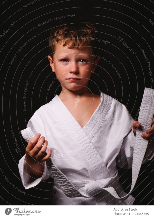 Trauriges Kind in weißer Kimono-Uniform im Atelier Junge Karate expressiv Freude sorgenfrei Individualität Vorschein Kindheit heiter Kultur Inhalt angenehm