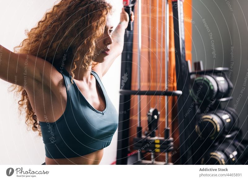 Sportlerin trainiert tagsüber im Fitnessstudio hispanisch Mischrennen stark Training Übung Maschine üben Sportkleidung Frau Motivation Ausdauer Sportbekleidung
