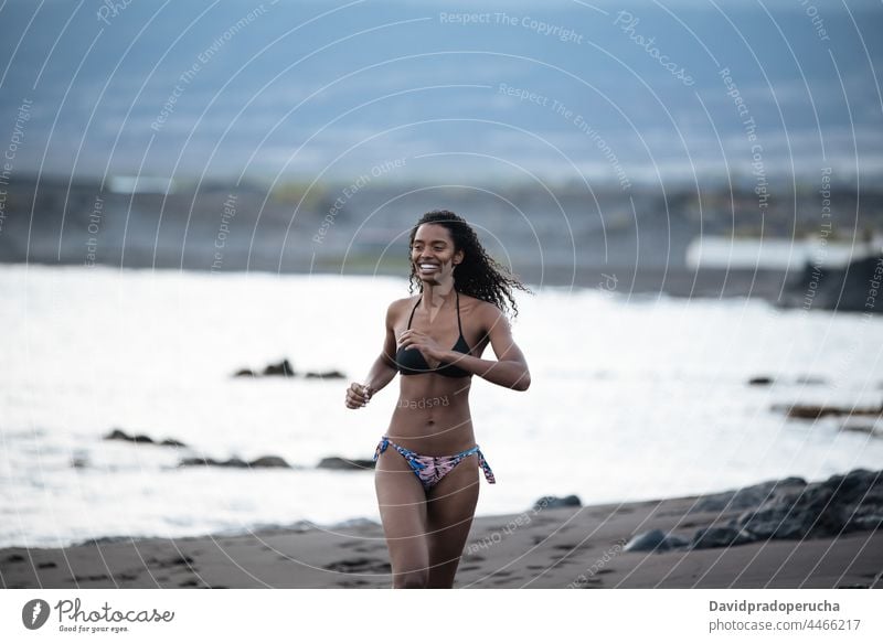 Frau im Bikini an einem vulkanischen Strand ethnisch Insel Seeküste schön passen Santo Antão Lächeln Afrikanisch sexy Kap Verde Feiertag horizontal rennen