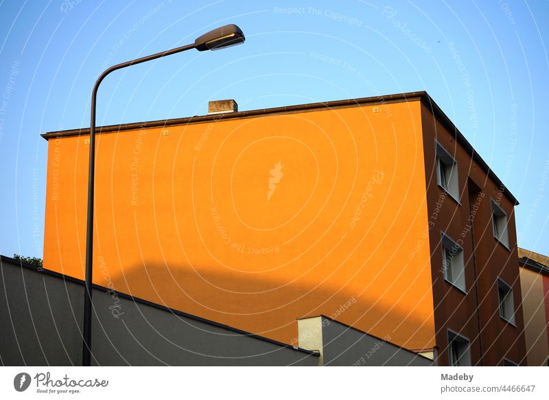 Orange gestrichene Fassade ohne Fenster mit Straßenlaterne im Licht der Abendsonne im Stadtteil Bornheim in Frankfurt am Main in Hessen Haus Architektur orange