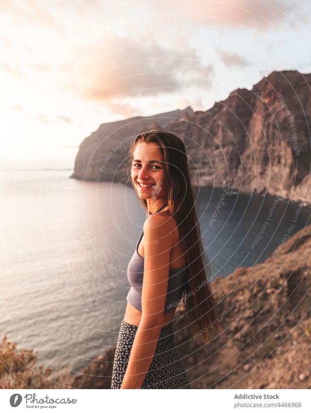 Glückliche Frau, die ihr Haar auf einem Berg gegen das Meer bei Sonnenuntergang berührt Berge u. Gebirge MEER Himmel Natur Hochland Landschaft Horizont endlos