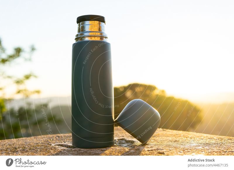 Thermoskanne mit Becher auf Steinoberfläche im Sonnenlicht Tasse Design kreativ modern Vakuum Flasche Heißgetränk Himmel Sonnenschein Getränk Kunststoff