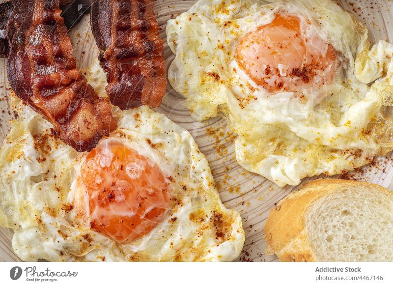 Leckeres Frühstück mit Spiegeleiern und Speckscheiben Ei gebraten Lebensmittel Mahlzeit Nährstoff geschmackvoll Teller Streifen Spielfigur Gewürz Ernährung