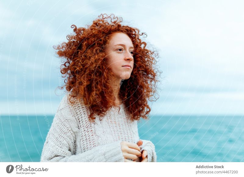 Nachdenkliche Frau am Meeresstrand MEER Persönlichkeit nachdenklich Individualität Porträt Meeresufer lange Haare Freude gestrickt Ingwerhaar Seeküste