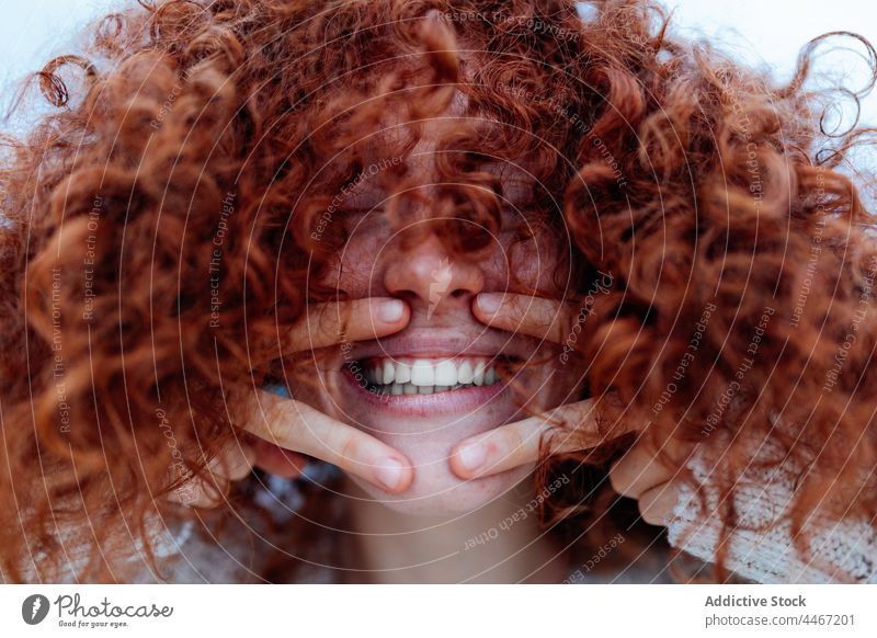 Fröhliche rothaarige Frau mit Siegesgeste Lachen zwei Finger Spaß Menschliches Gesicht Freude Glück gestikulieren Rotschopf Optimist v-Zeichen krause Haare
