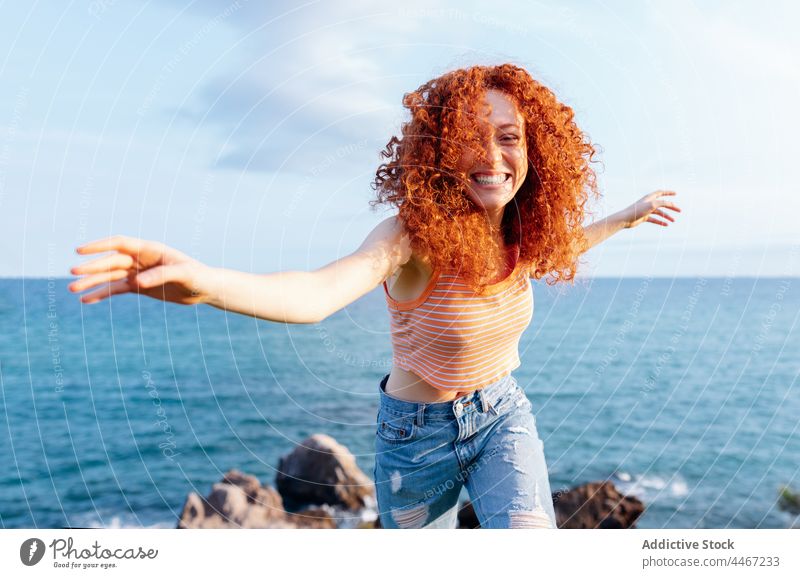 Unbekümmerte Frau tanzt auf einem Hügel an der Küste Tanzen genießen MEER sich[Akk] bewegen Energie Freiheit Glück expressiv Lächeln ausgestreckte Arme laufen
