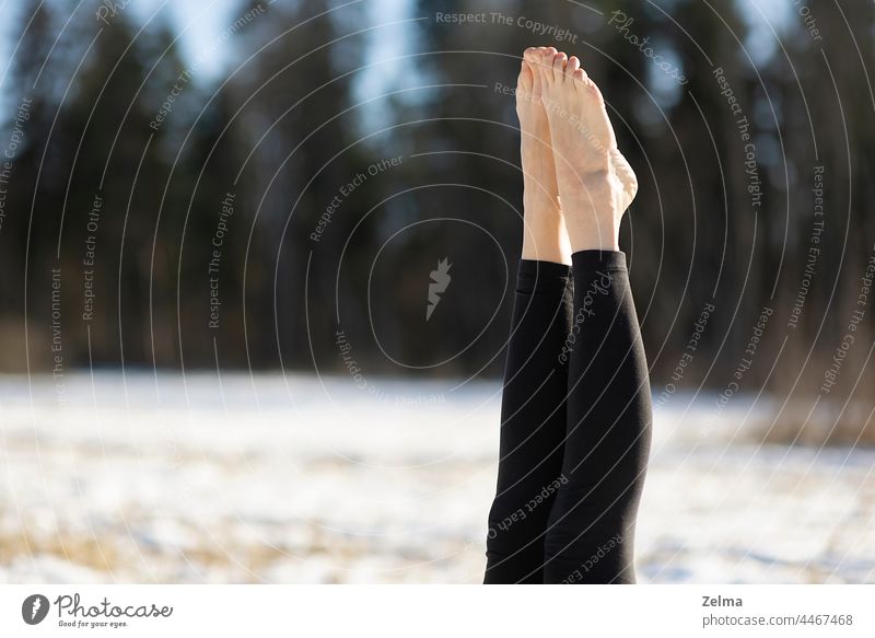 Nahaufnahme der Beine nackten Fußes der jungen attraktiven Frau übt Yoga auf verschneiten Feld Sport sportlich Sitzen meditierend Pose positionieren Schnee