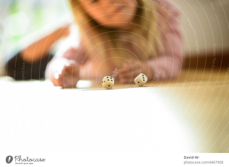 Kind spielt und würfelt mit zwei Würfeln würfeln spielen Spaß Mädchen Gesellschaftsspiele Spiel Freude Kindheit Zufriedenheit
