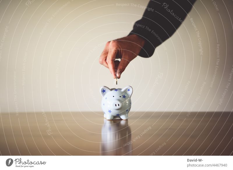 Münze in ein Sparschwein werfen Spardose sparen Geld Euromünzen Hand Mann Geldmünzen Erfolg sparsam Zukunft Zukunftsorientiert