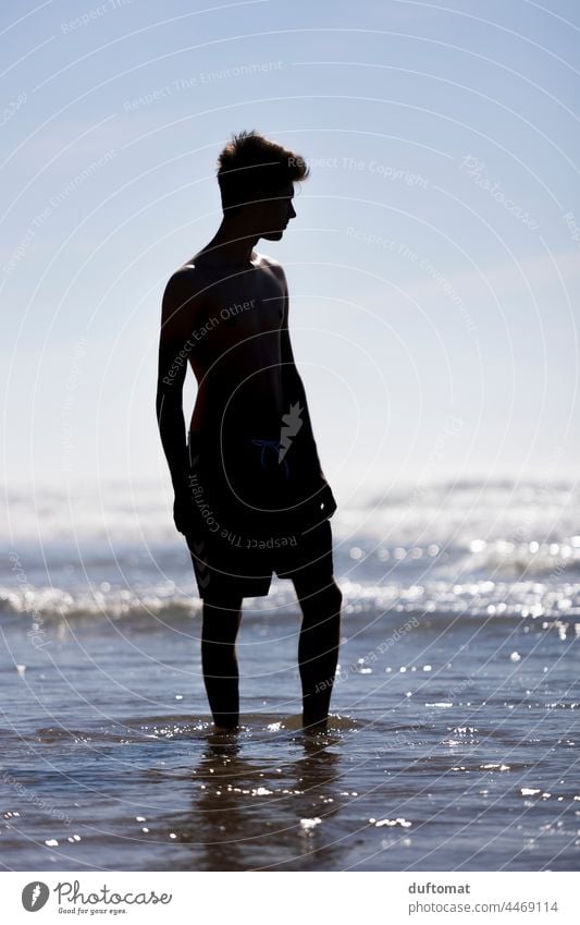 Silhouettenbild eines jungen Mannes, der im Meerwasser steht Wasser Wellen Brandung Mensch Junger Mann Strand Erholung junger Erwachsener Küste Lifestyle