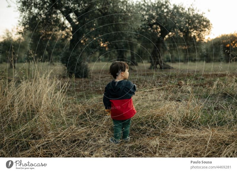 Ein Kind steht auf dem Feld Kindheit Rückansicht Kaukasier warme Kleidung Herbst authentisch Lifestyle Natur Mensch Außenaufnahme Farbfoto Leben
