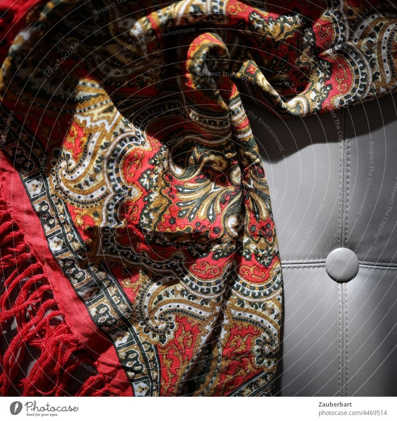 Faltenwurf einer roten Decke mit Paisley-Muster im Sonnenlicht auf Lederpolster Schatten Polster Strukturen & Formen Stoff Textilien Dekoration & Verzierung