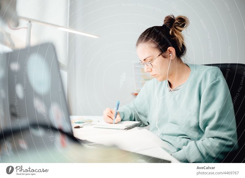 Mädchen, das von zu Hause aus am Laptop arbeitet oder Studentin, die von zu Hause aus studiert oder Freiberuflerin. Online-Arbeit, spätabendliche Schreibtischarbeit, Heimbüro